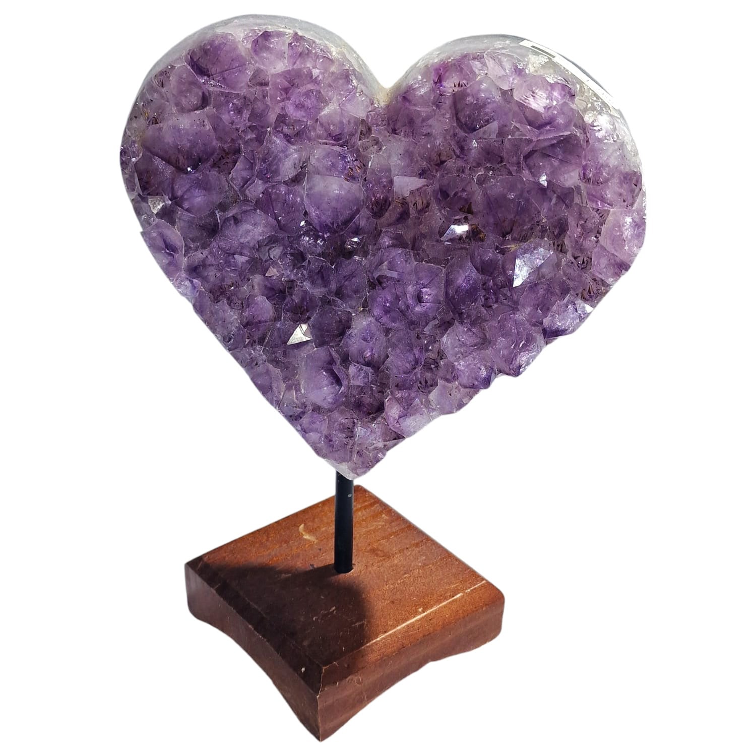 GeoFossils polished Amethyst Heart displayed on a handcrafted wooden stand. The heart-shaped stone features deep purple hues with natural variations, highlighting Amethyst's signature calming and protective qualities. The elegant wooden stand complements the crystal, creating a stunning and serene display perfect for any setting.